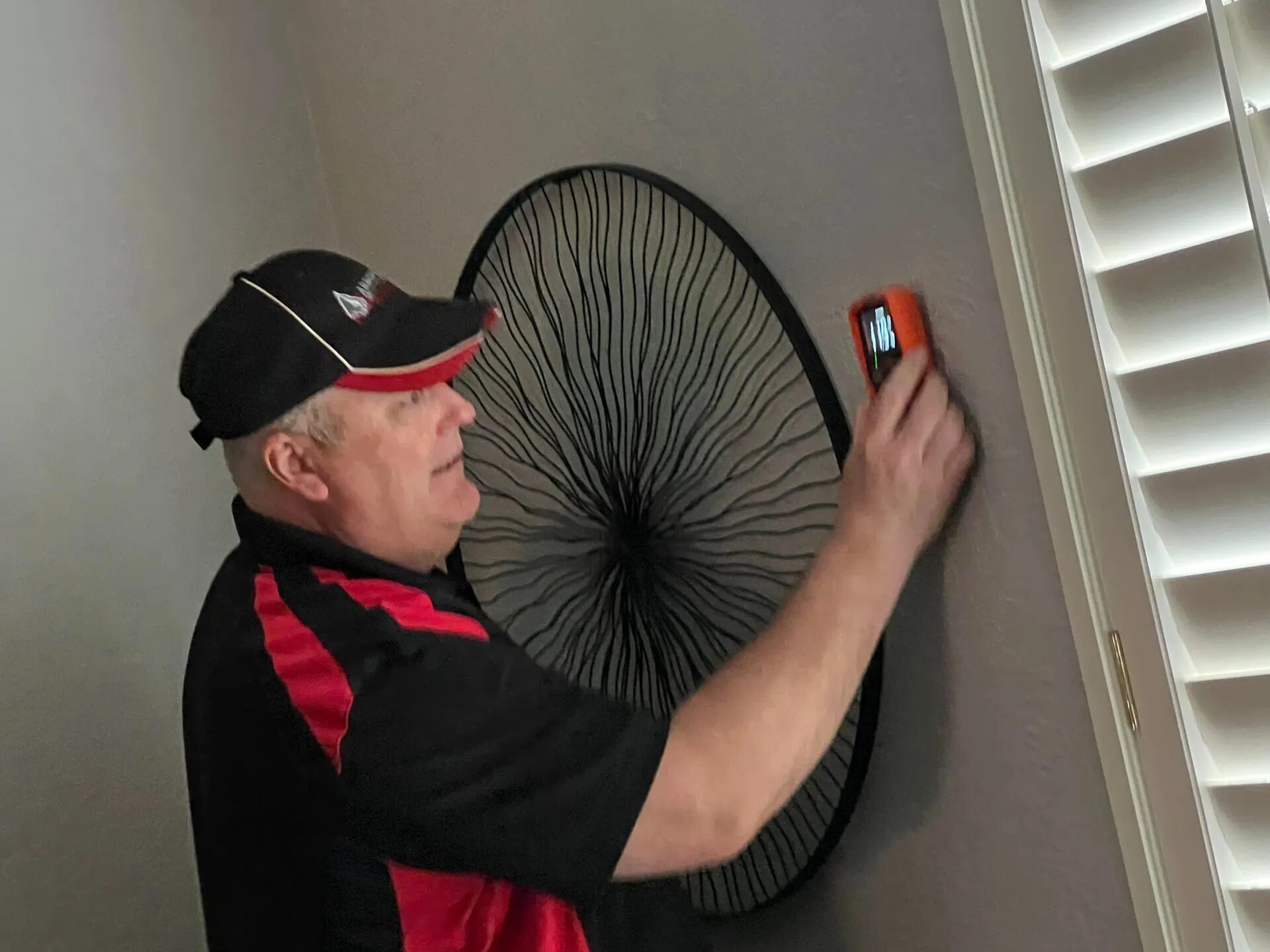 Edward Hagstrom using a moisture meter to inspect an interior wall